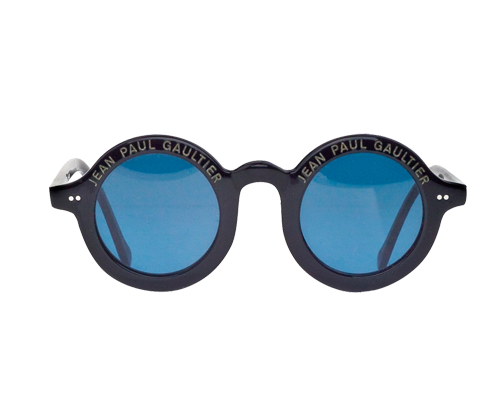 Occhiali da sole con montatura rotonda di colore blu, lenti celesti, scritta Jean Paul Gaultier sopra entrambi le lenti di colore bianco